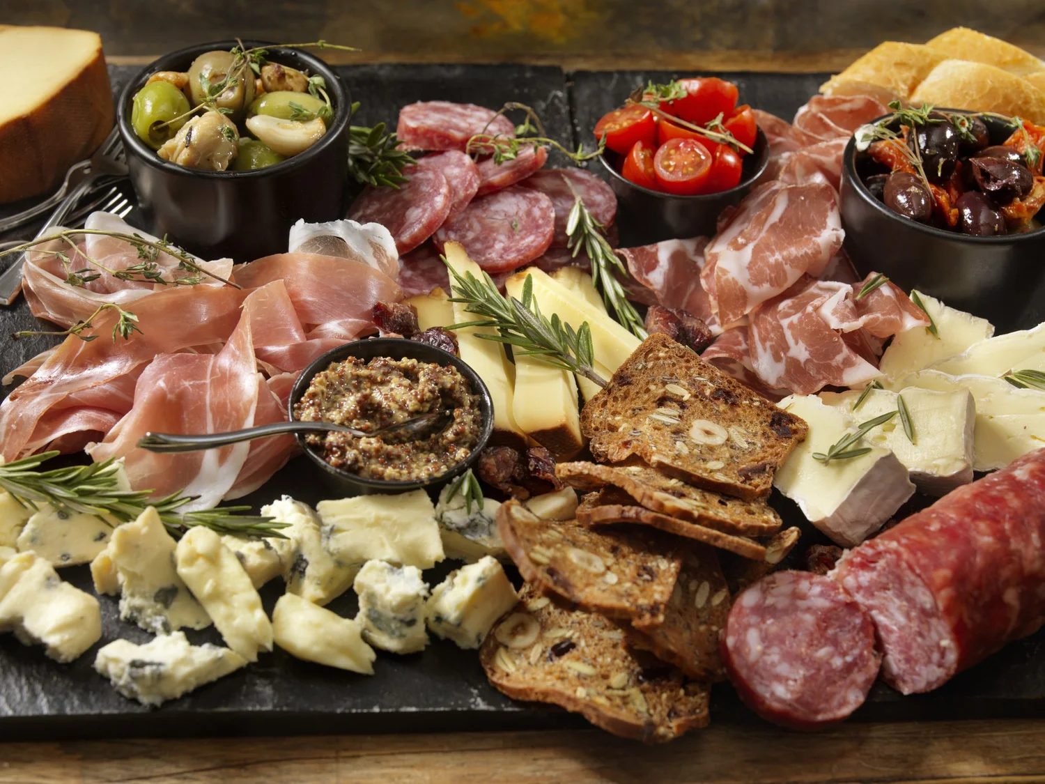 A charcuterie board with cured meats, cheeses, and accompaniments
